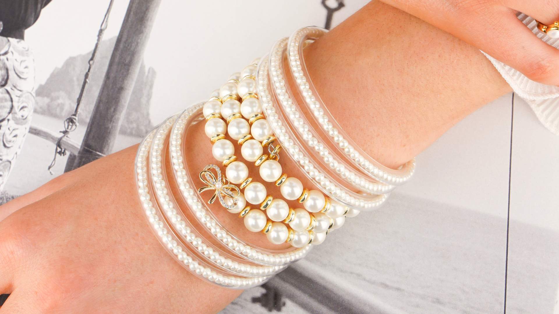 Shop All Collection Banner Featuring Woman Sitting Near Pool Cabana Wearing White Pearl Bangle Bracelets for Women | BuDhaGirl