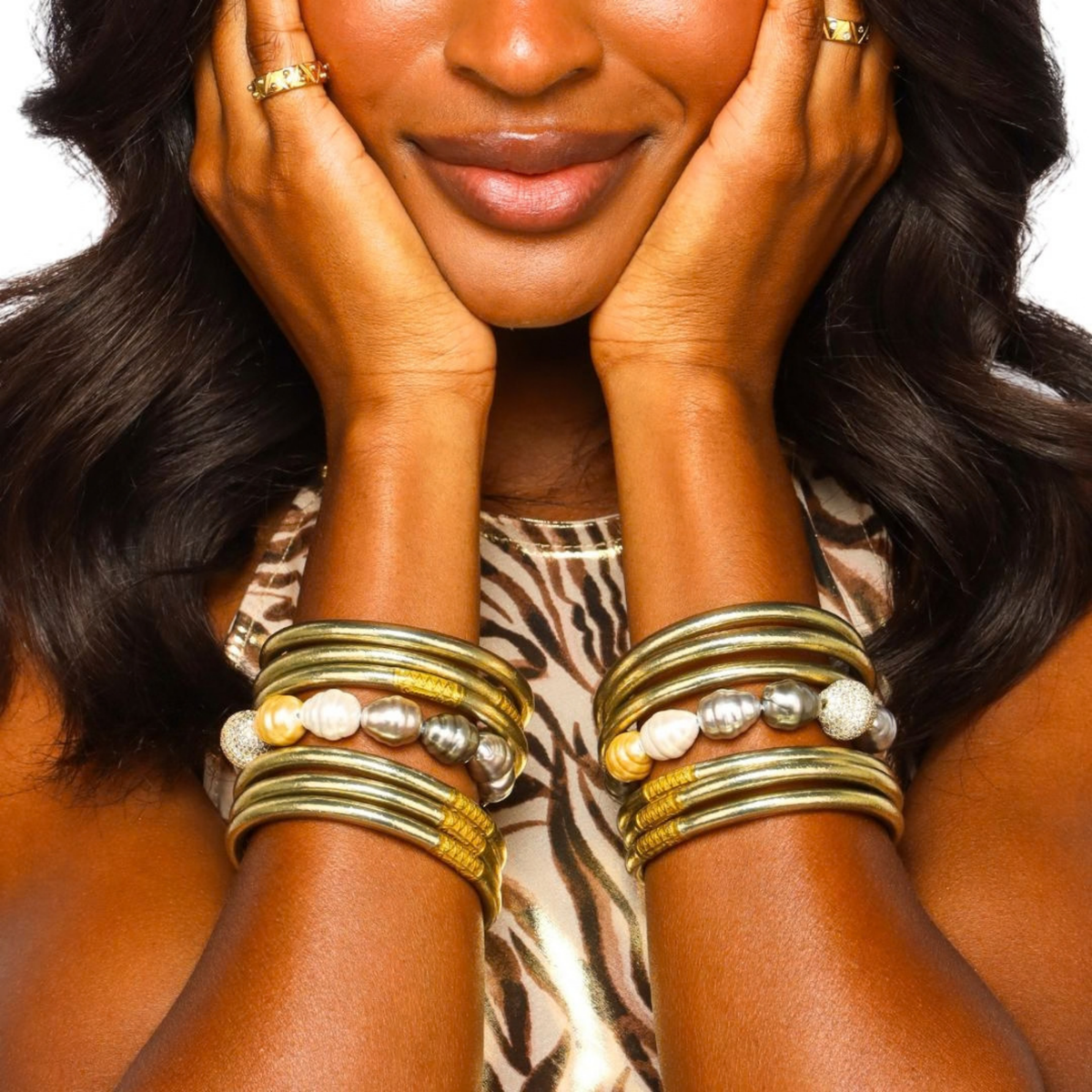 BuDhaGirl bangle bracelets for women stacked in gold and silver tones with pearl and beaded accents on a woman wearing a bold animal print top