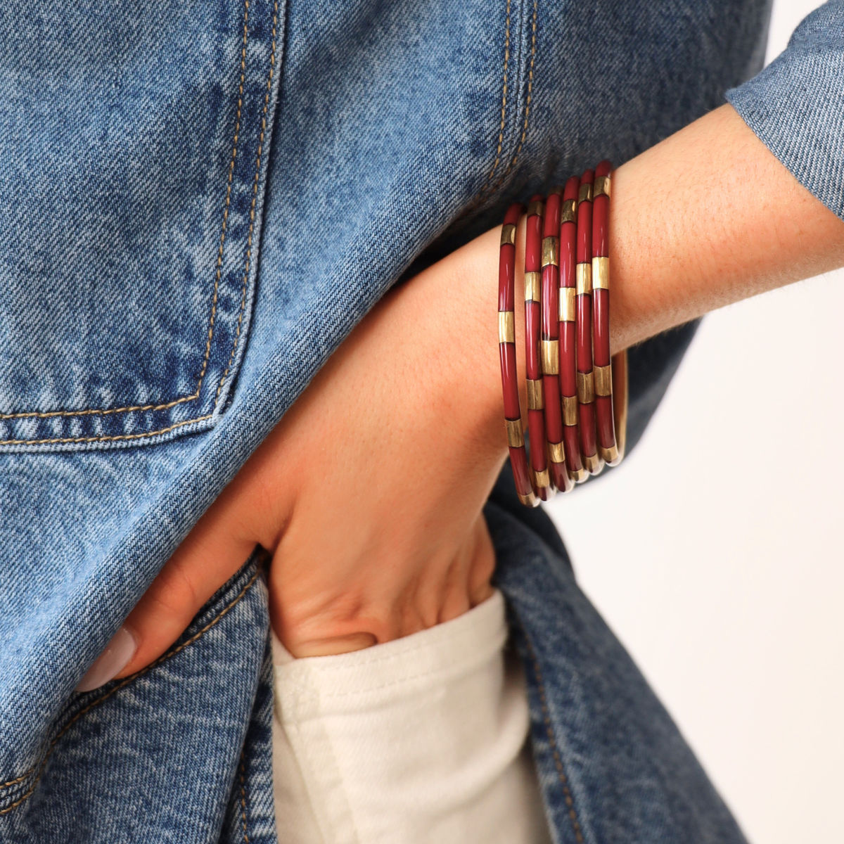 a person wearing a red and gold bracelet