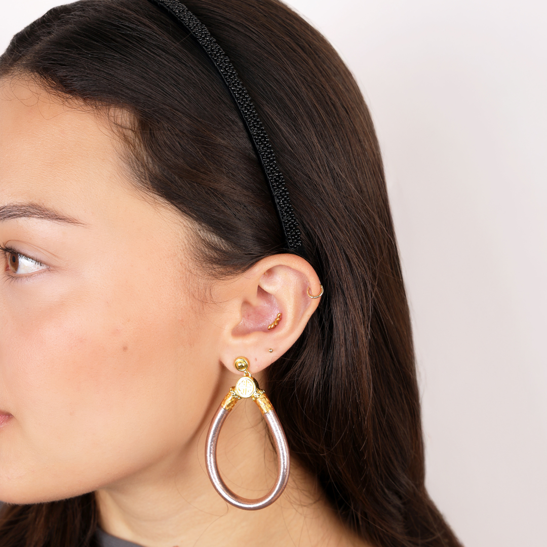 a woman wearing earrings and a headband