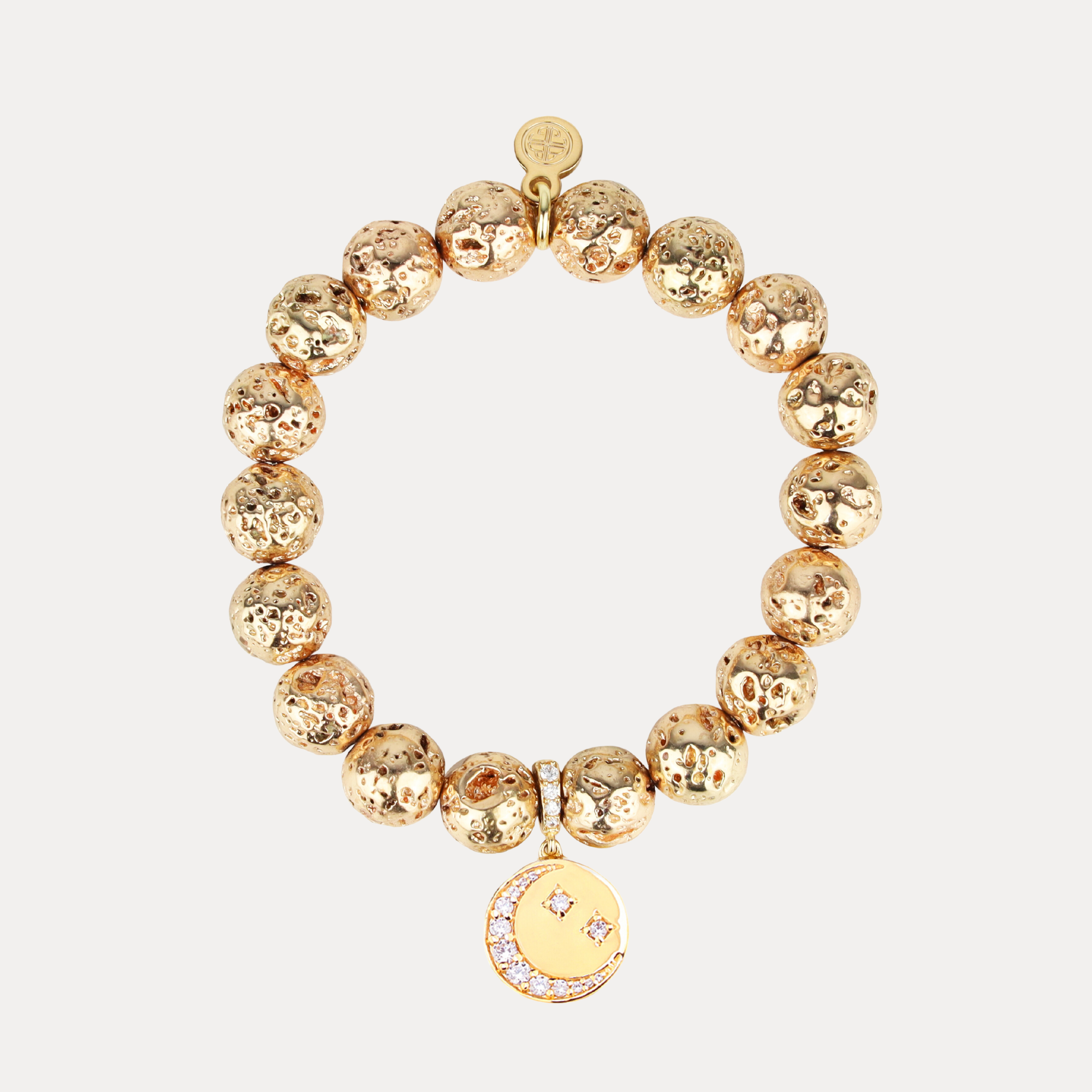 Gold beaded bracelet with a circular charm on a white background