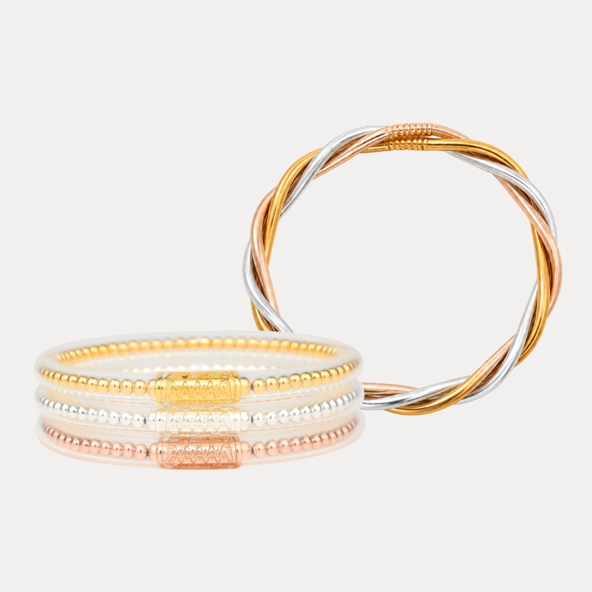 Two gold bangles on a light gray background