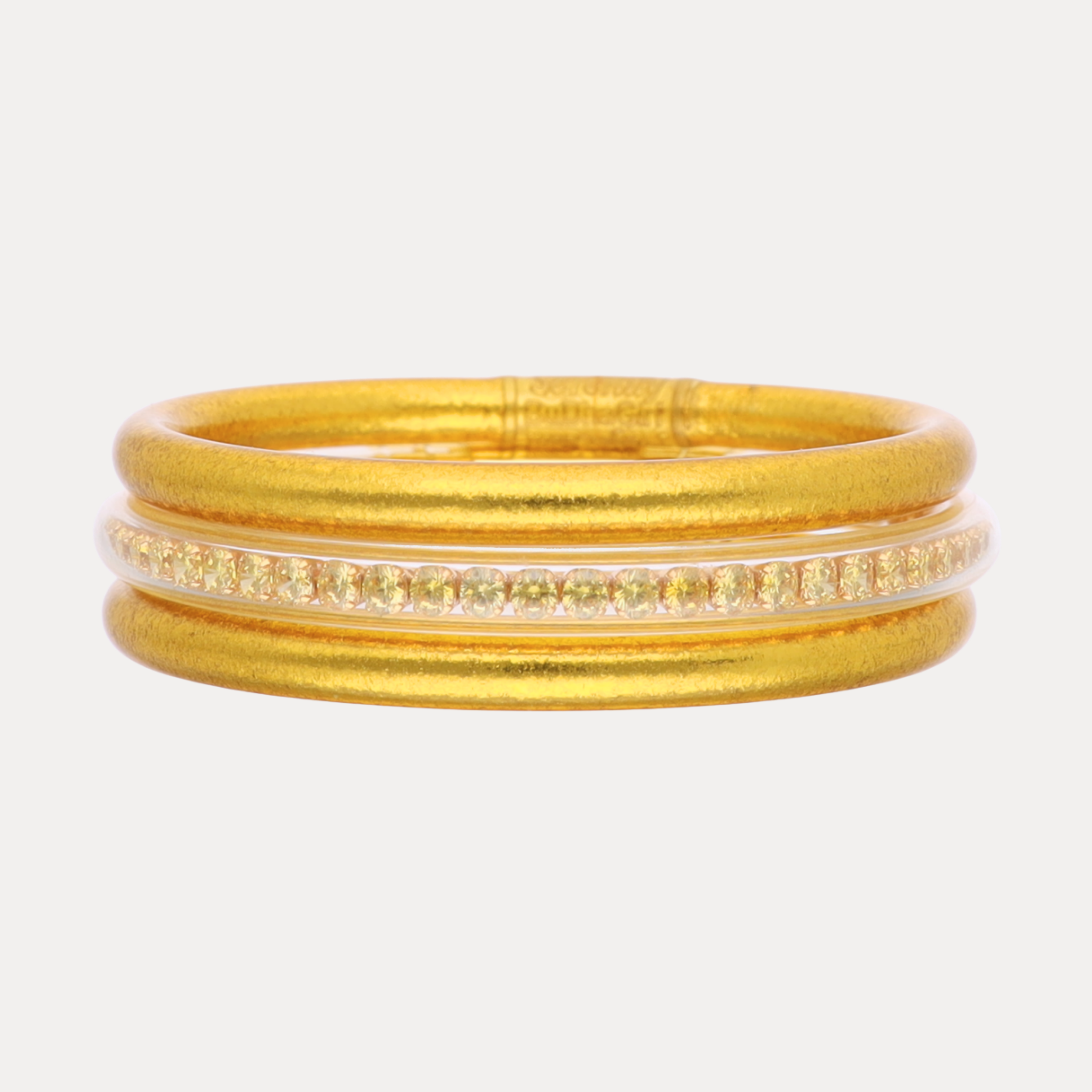 Set of gold bangles on a white background