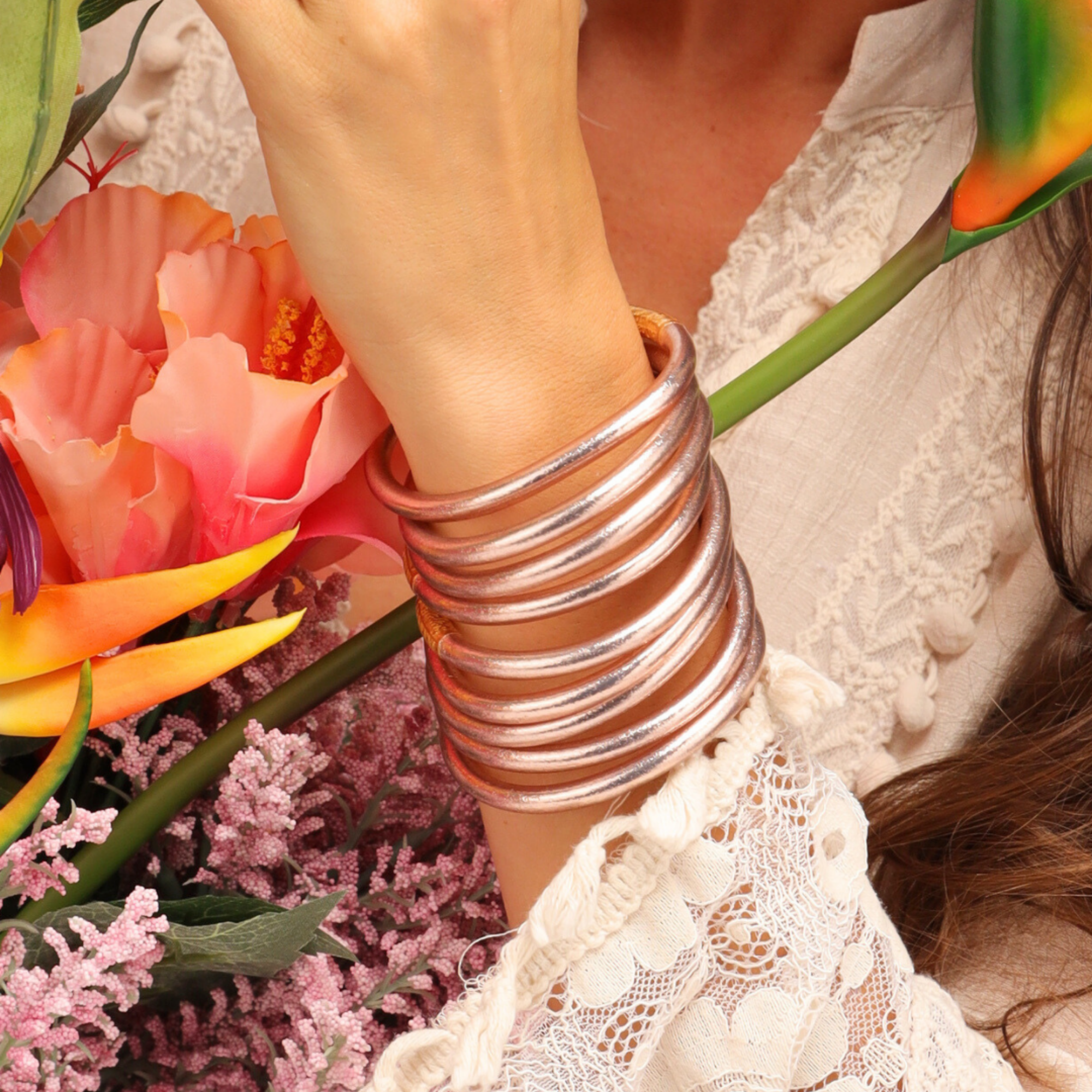 Person wearing a silver bracelet with a bouquet of flowers