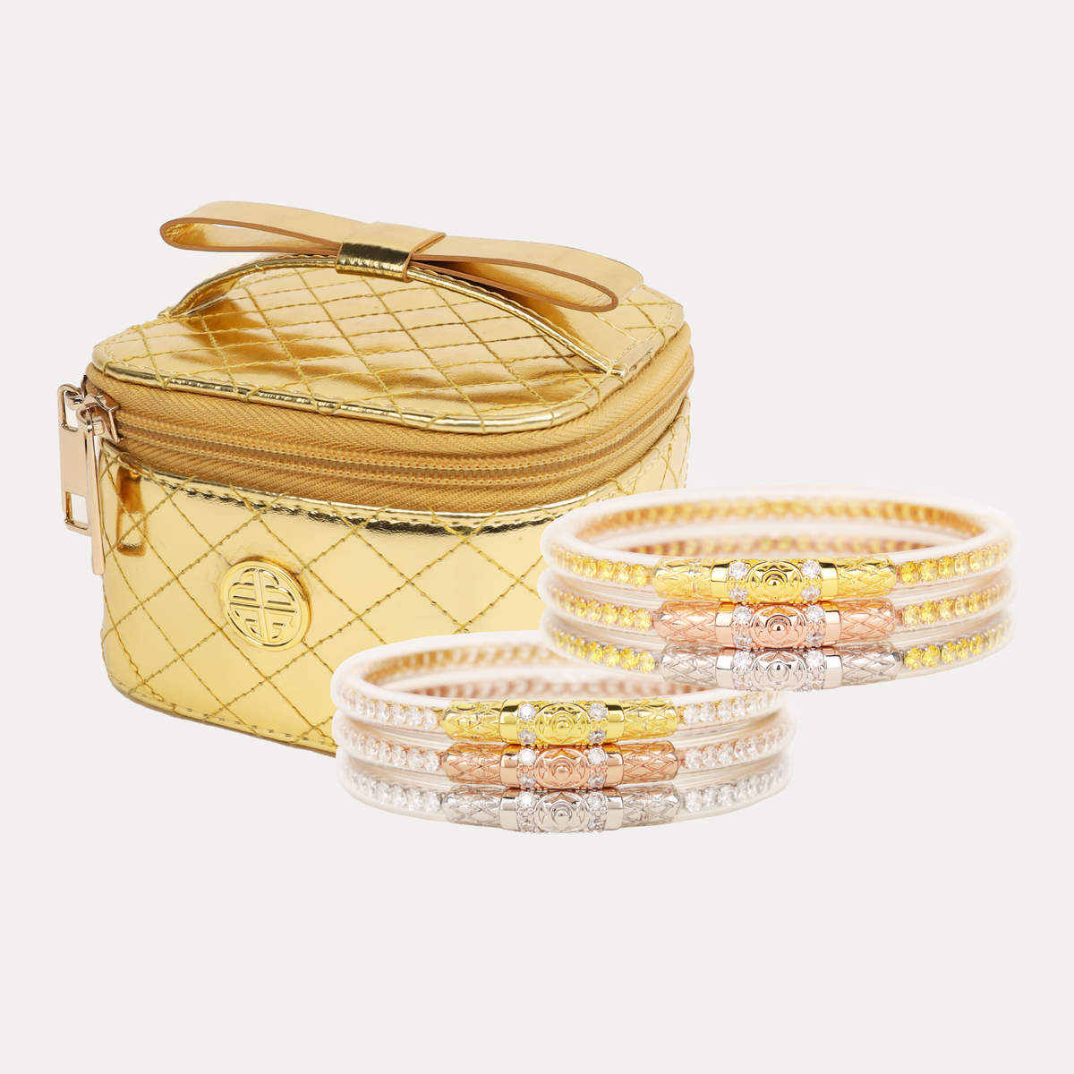 BuDhaGirl bangle bracelets for women in clear crystal and yellow rose tones displayed beside a quilted gold jewelry case in a six piece bundle