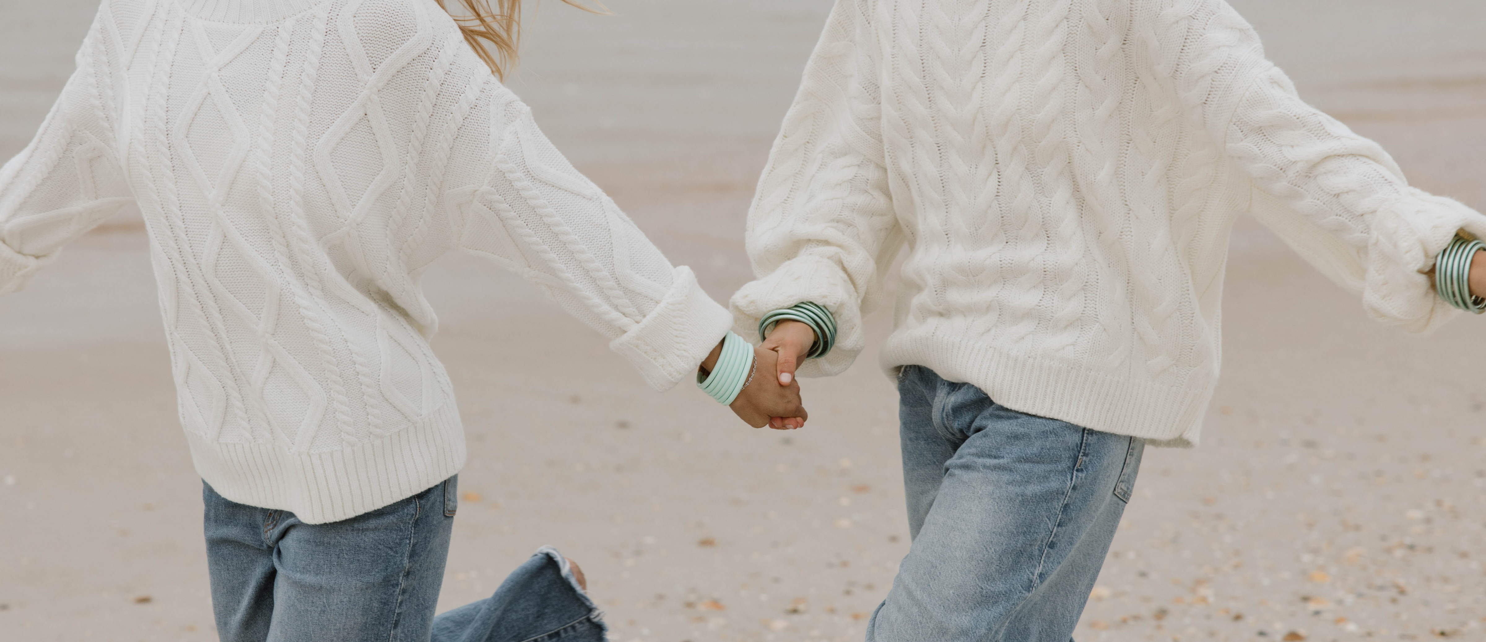 a couple holding hands on a beach