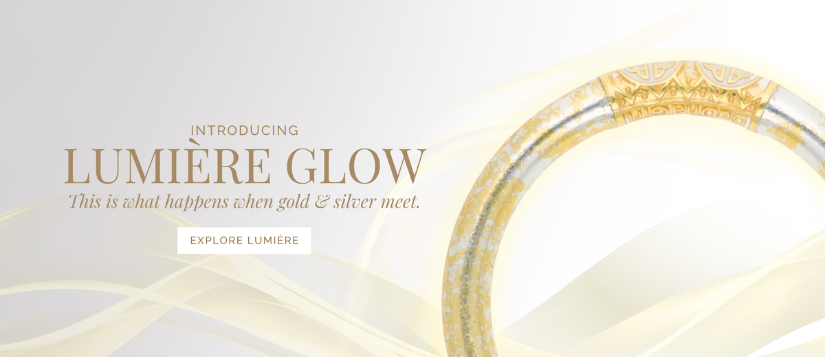 Introducing Lumière Glow banner with a shimmering gold and silver bangle bracelet on flowing cream and white abstract waves and an Explore Lumière button