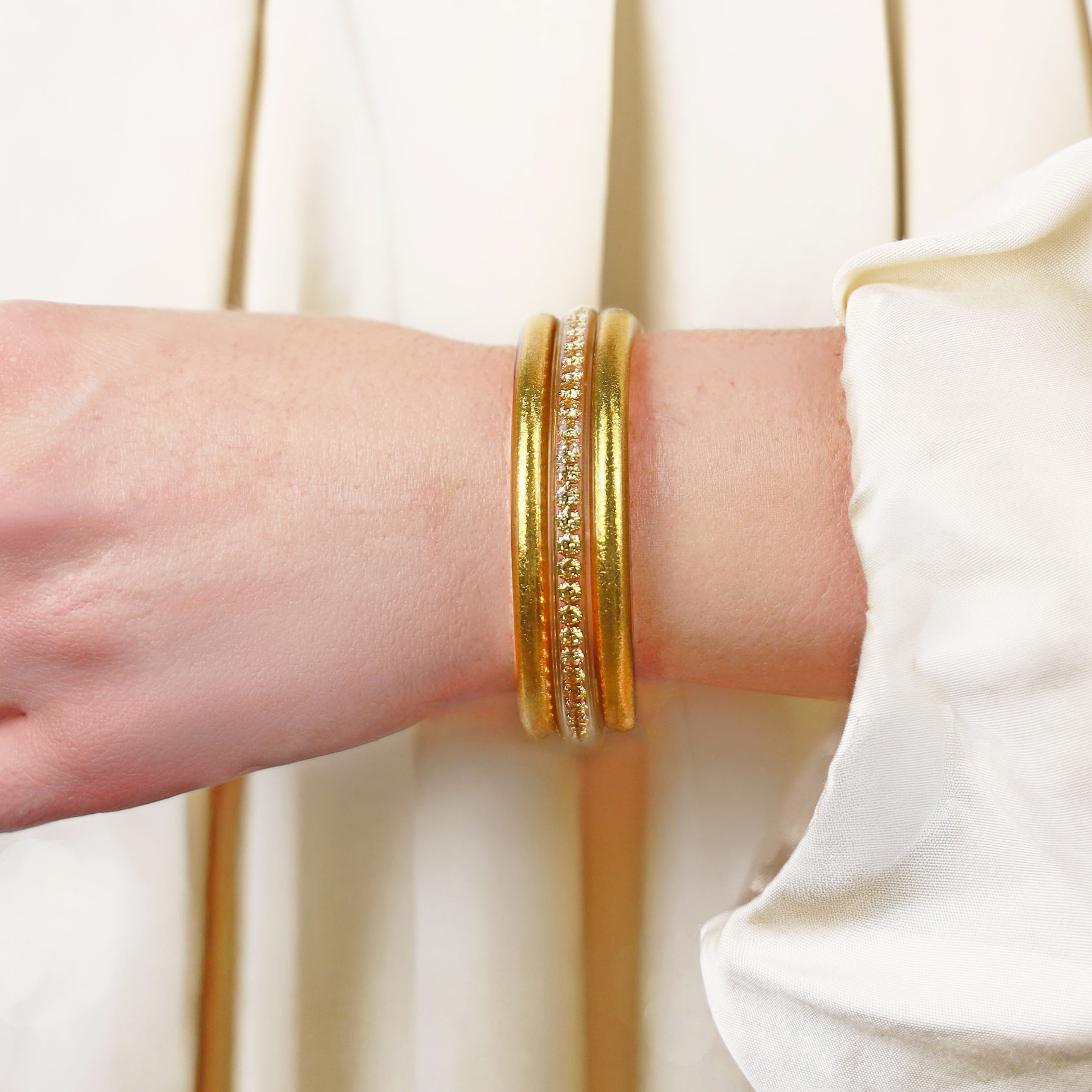 Set of gold bangles on a white background