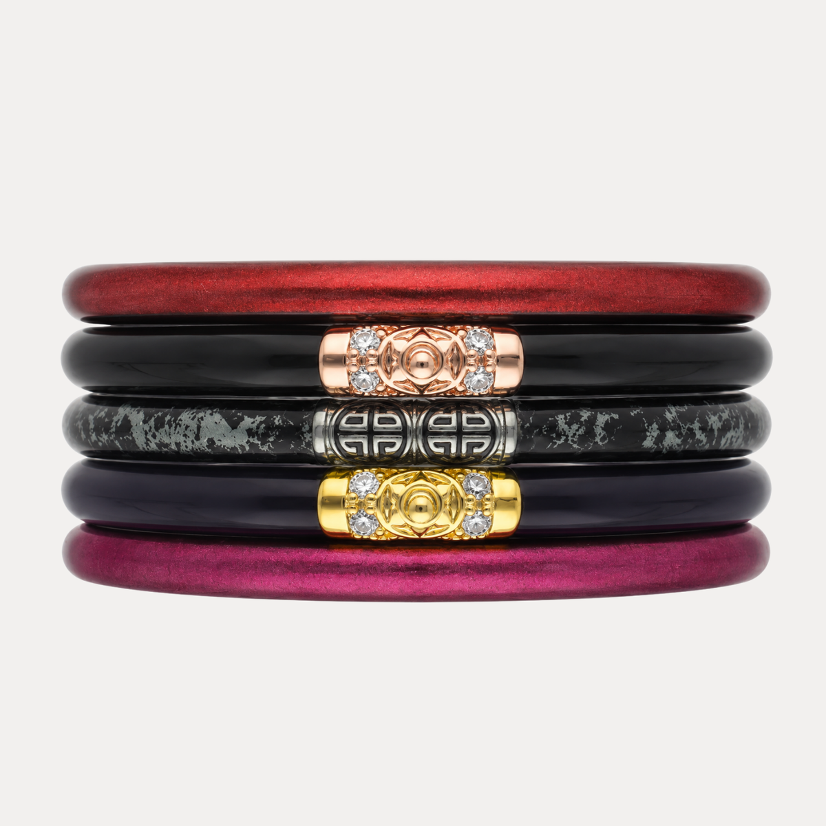 Five stacked bangle bracelets in red, black, marbled gray, deep purple, and burgundy, with rose gold, silver, and gold decorative center accents