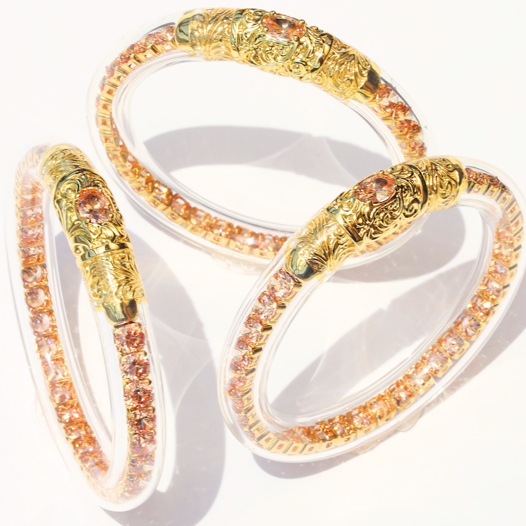 a group of bracelets with gold and orange stones
