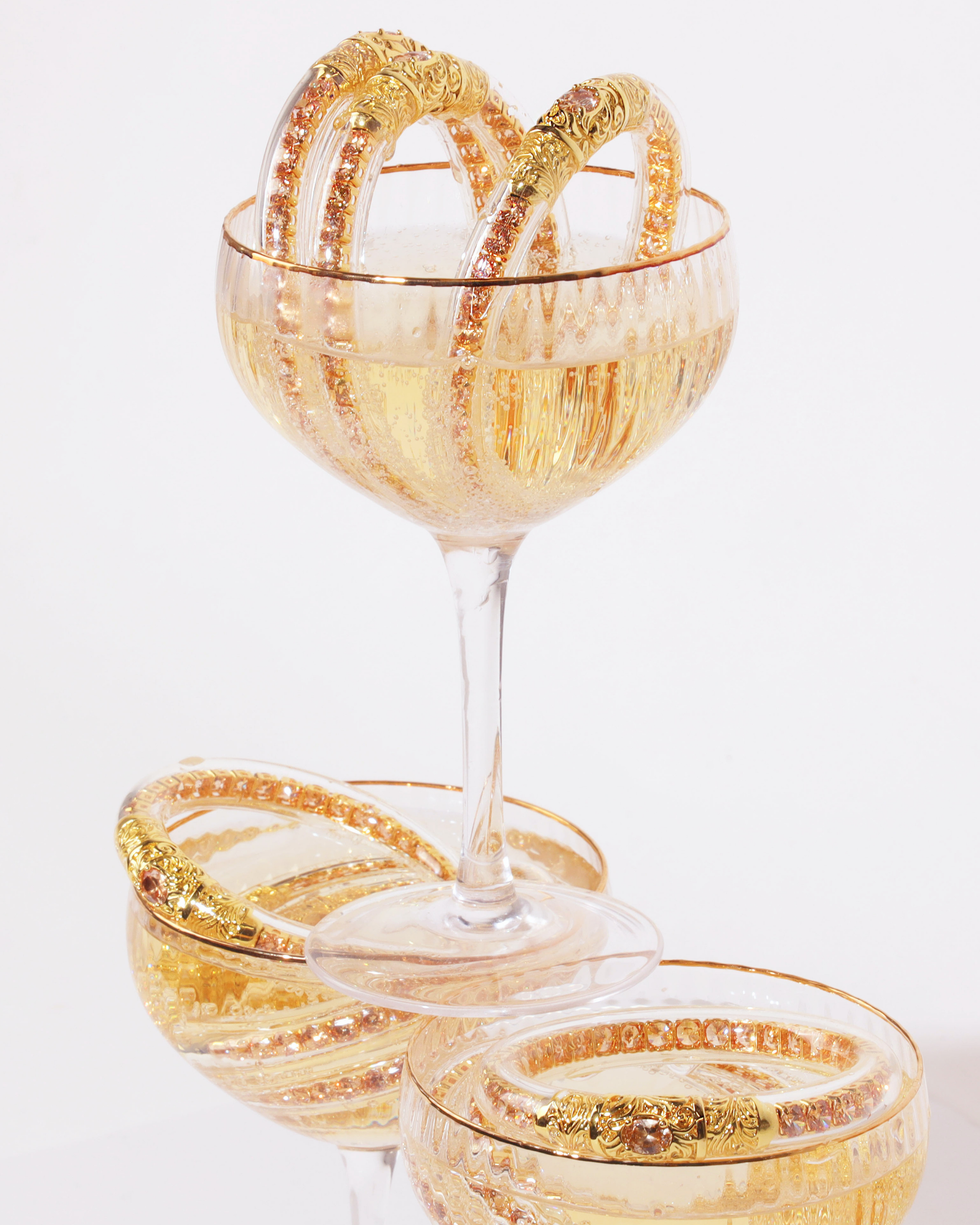 a glass with gold bracelets in it