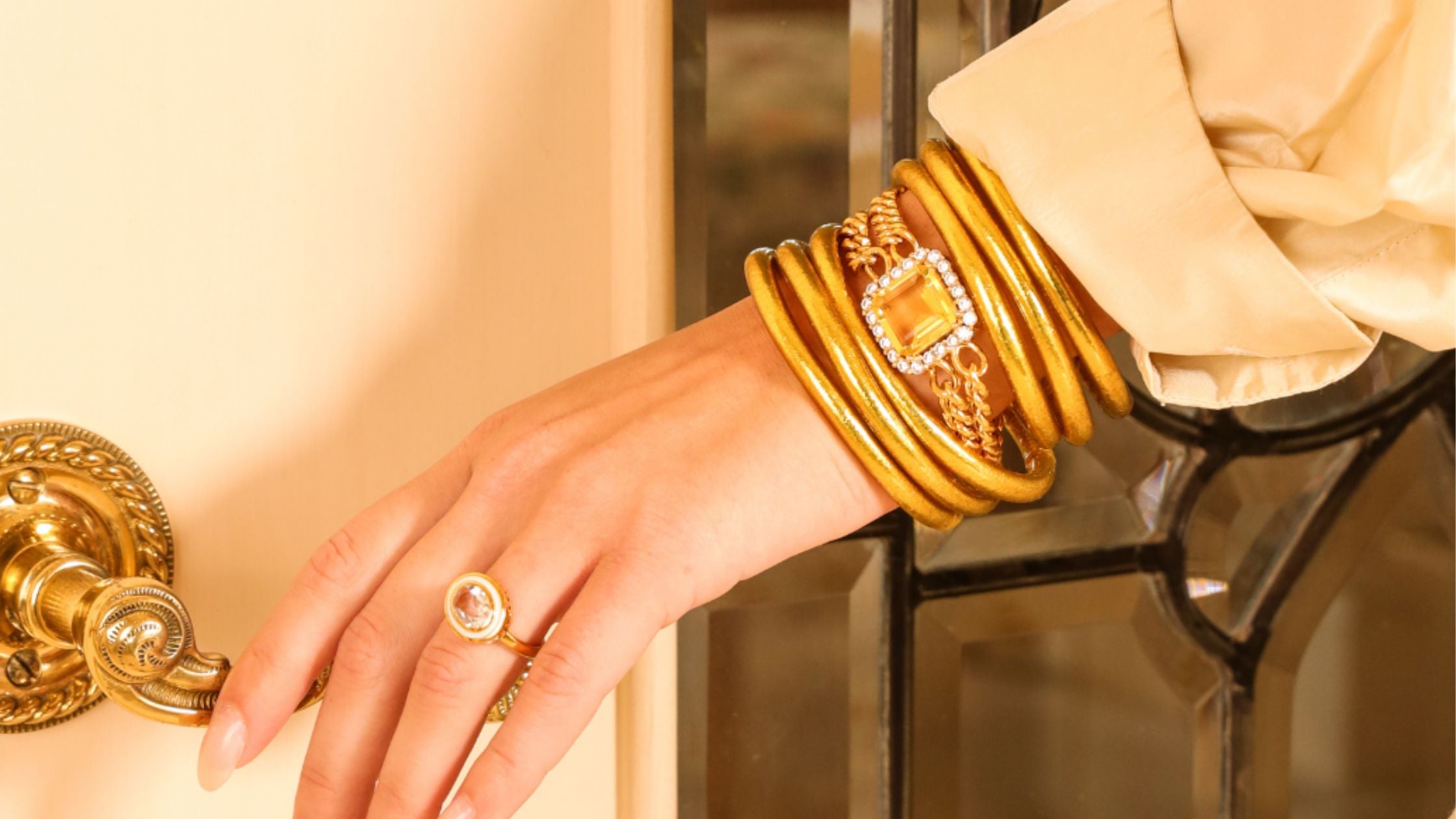 women wearing gold all weather bangles and solange bracelet.