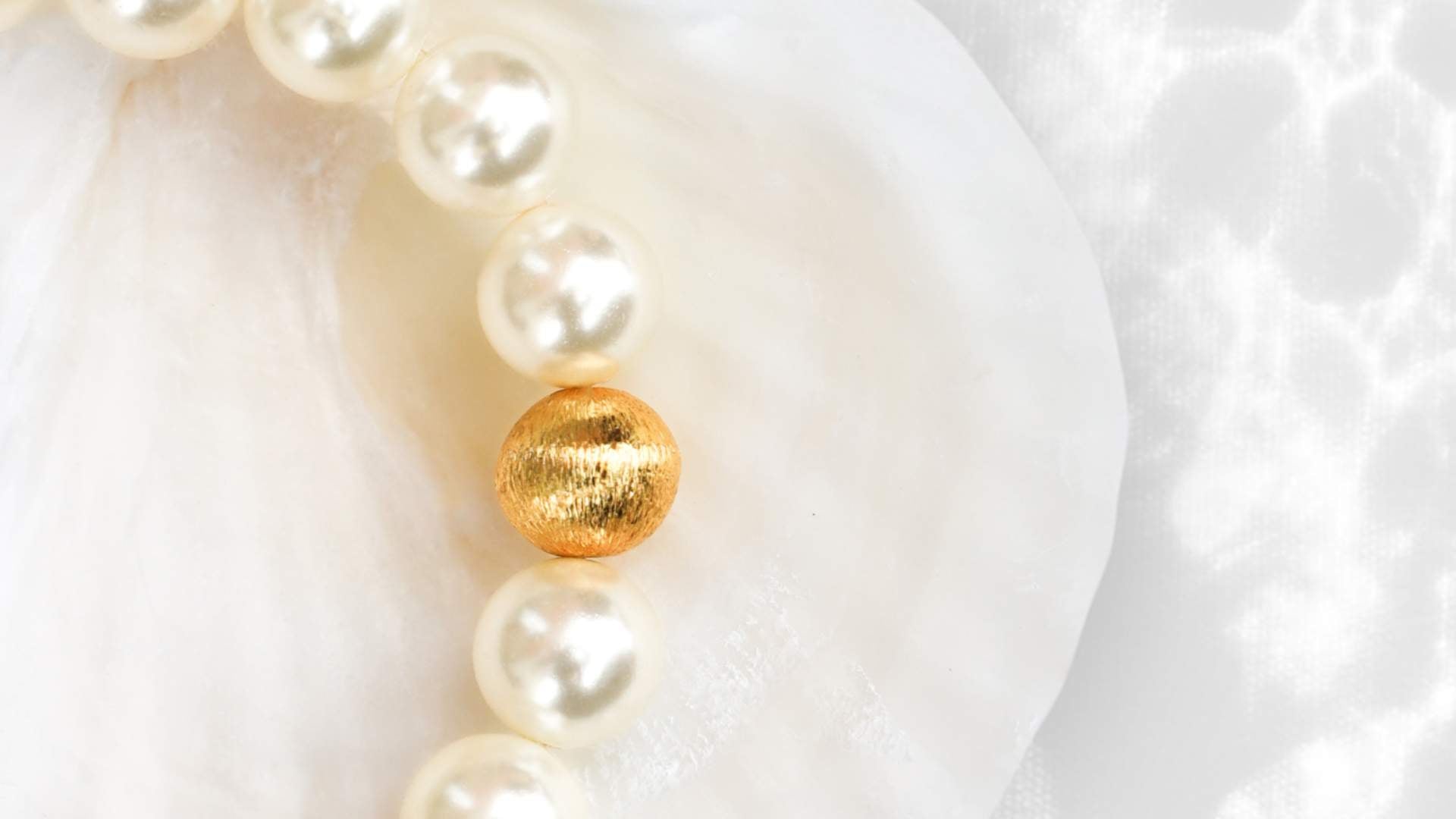 New Arrivals Collection Banner Featuring White Pearl Mala Bracelet with Gold Accent Brush Bead Inside Sea Shell | BuDhaGirl
