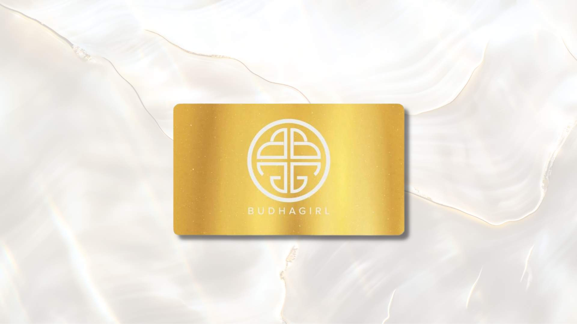 A gold BuDhaGirl Gift Card with a white logo on a gray background.