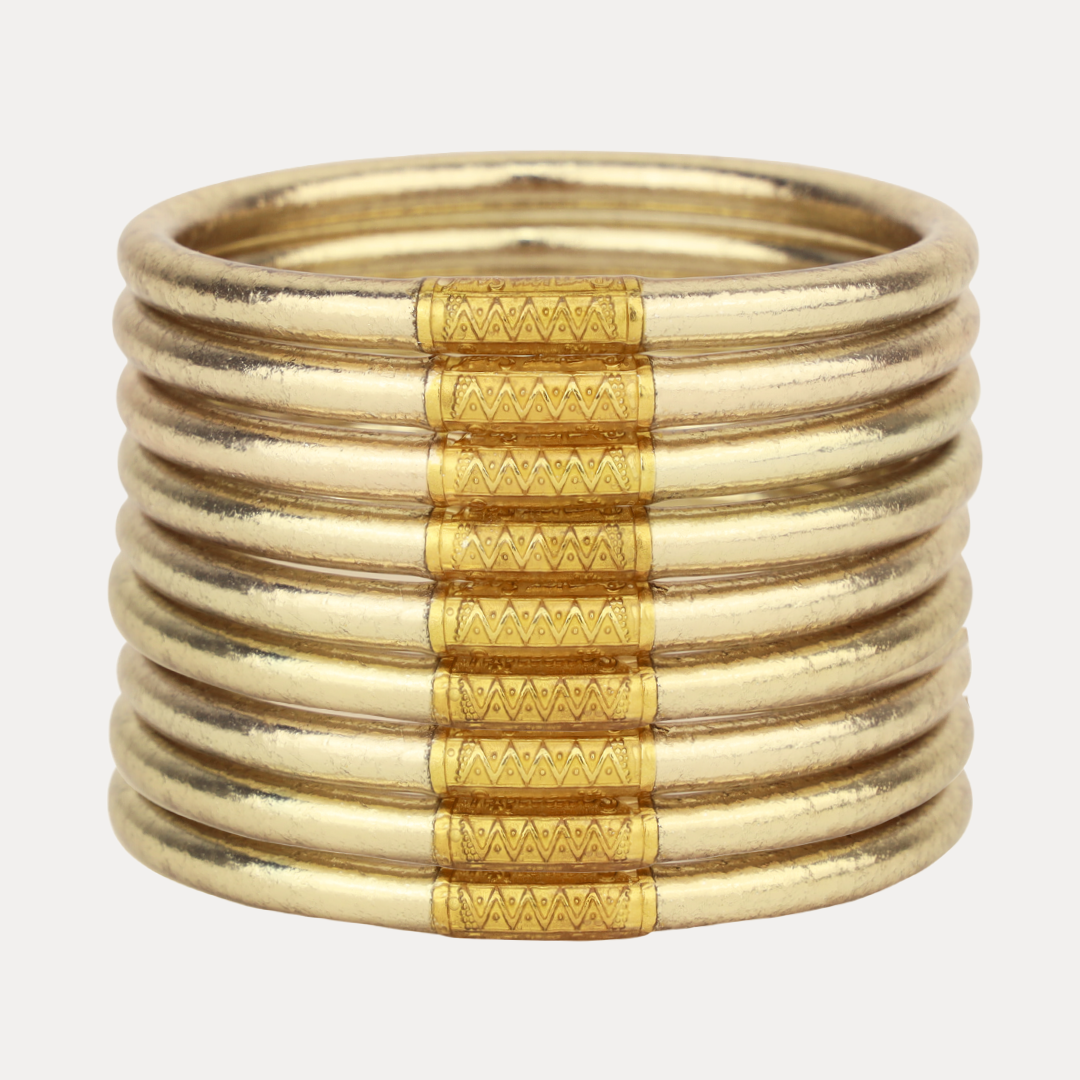 Stack of gold bangles on a white background