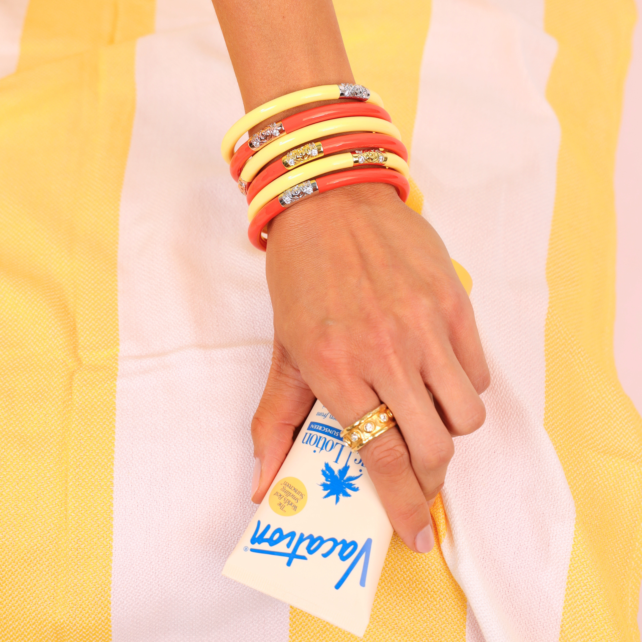 a hand with bracelets and a package of cream