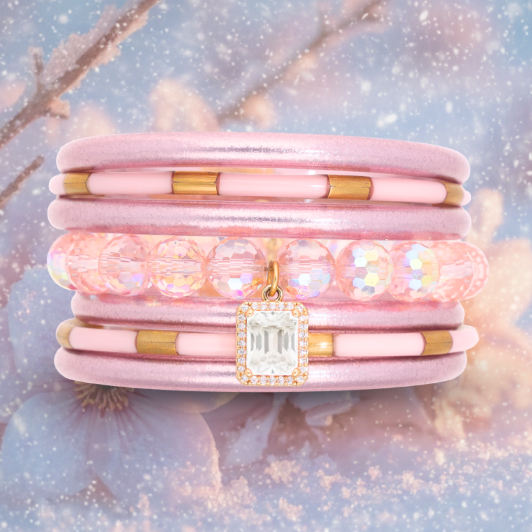 a pink bracelet with a gold pendant