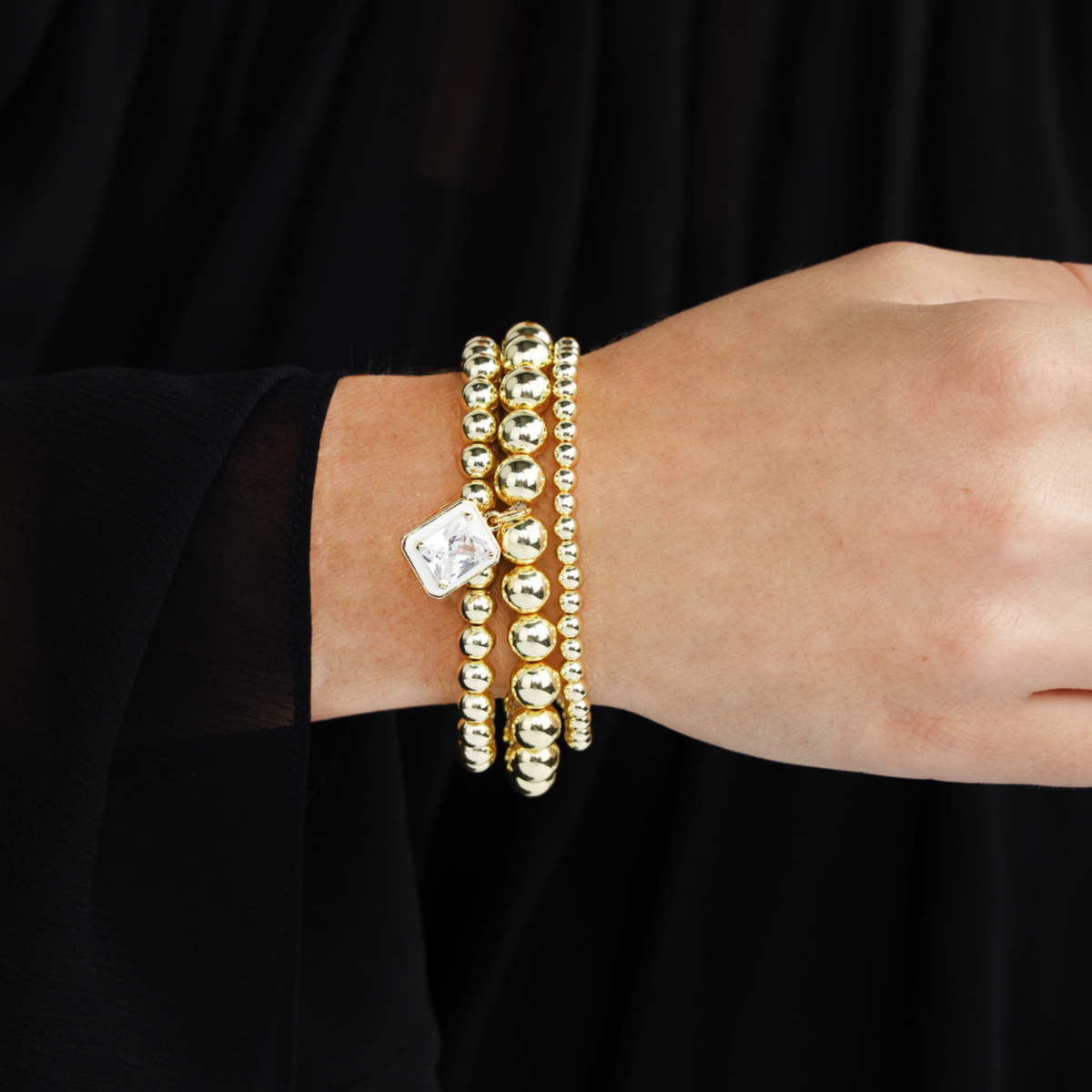 BuDhaGirl bangle bracelets for women layered with golden beads and luminous white pearls with a square charm on the wrist