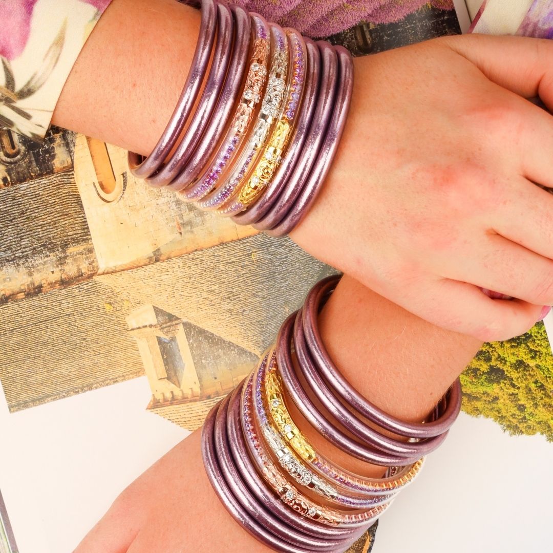 Woman with Hands Crossed on Top of Book Wearing Purple Lilac Bangle Bracelets | BuDhaGirl
