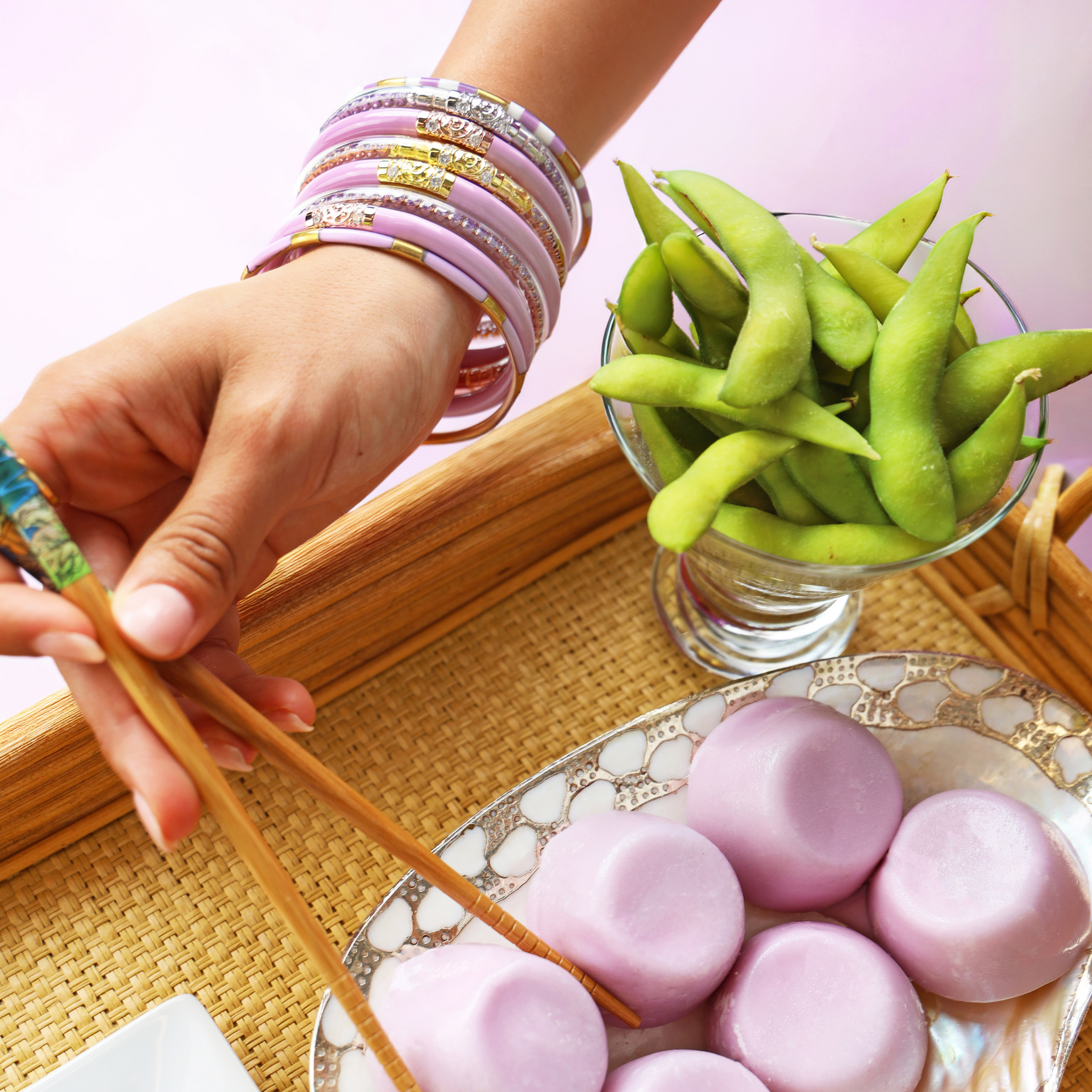 a person holding chopsticks over a plate of food