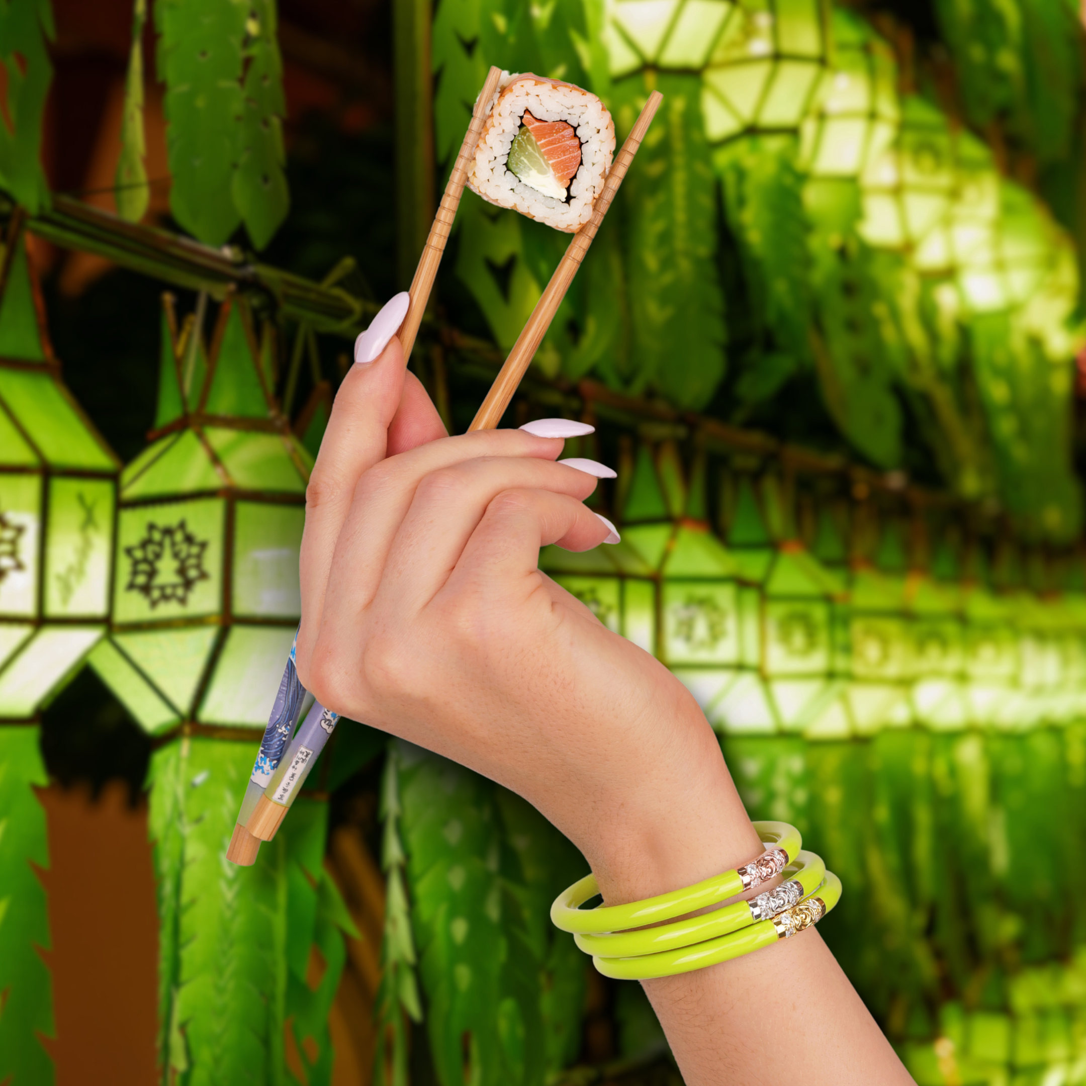 a hand holding sushi with chopsticks
