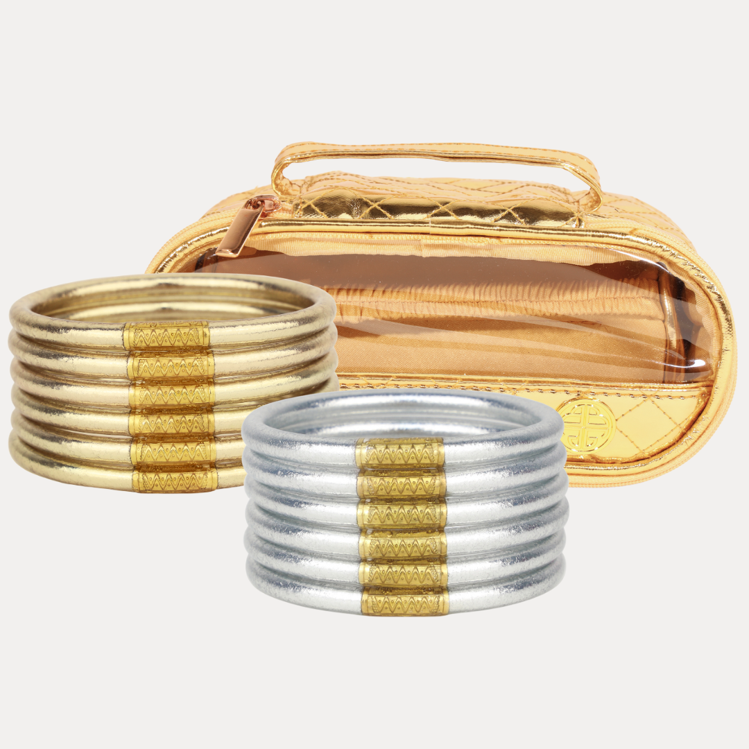 Set of gold and silver bangles with a carrying case on a white background